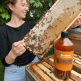 Load image into Gallery viewer, beekeeper happily inspecting the state of honey frames after application of bee-elixir