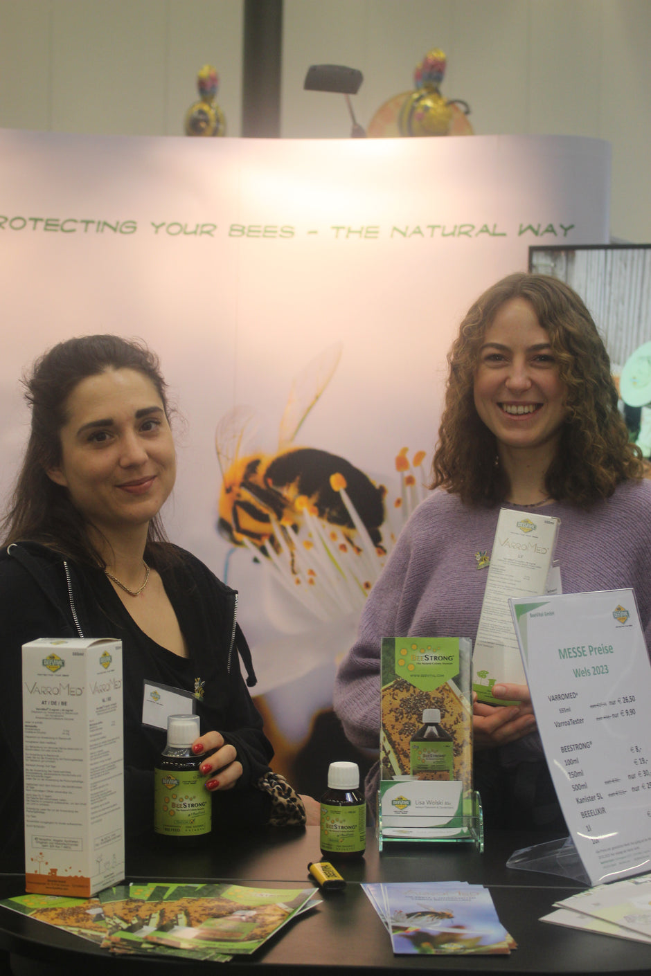 two girls holding beestrong bottles at the expo