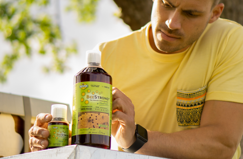 man looking closely at beestrong bottles of 1 liter and 100 ml