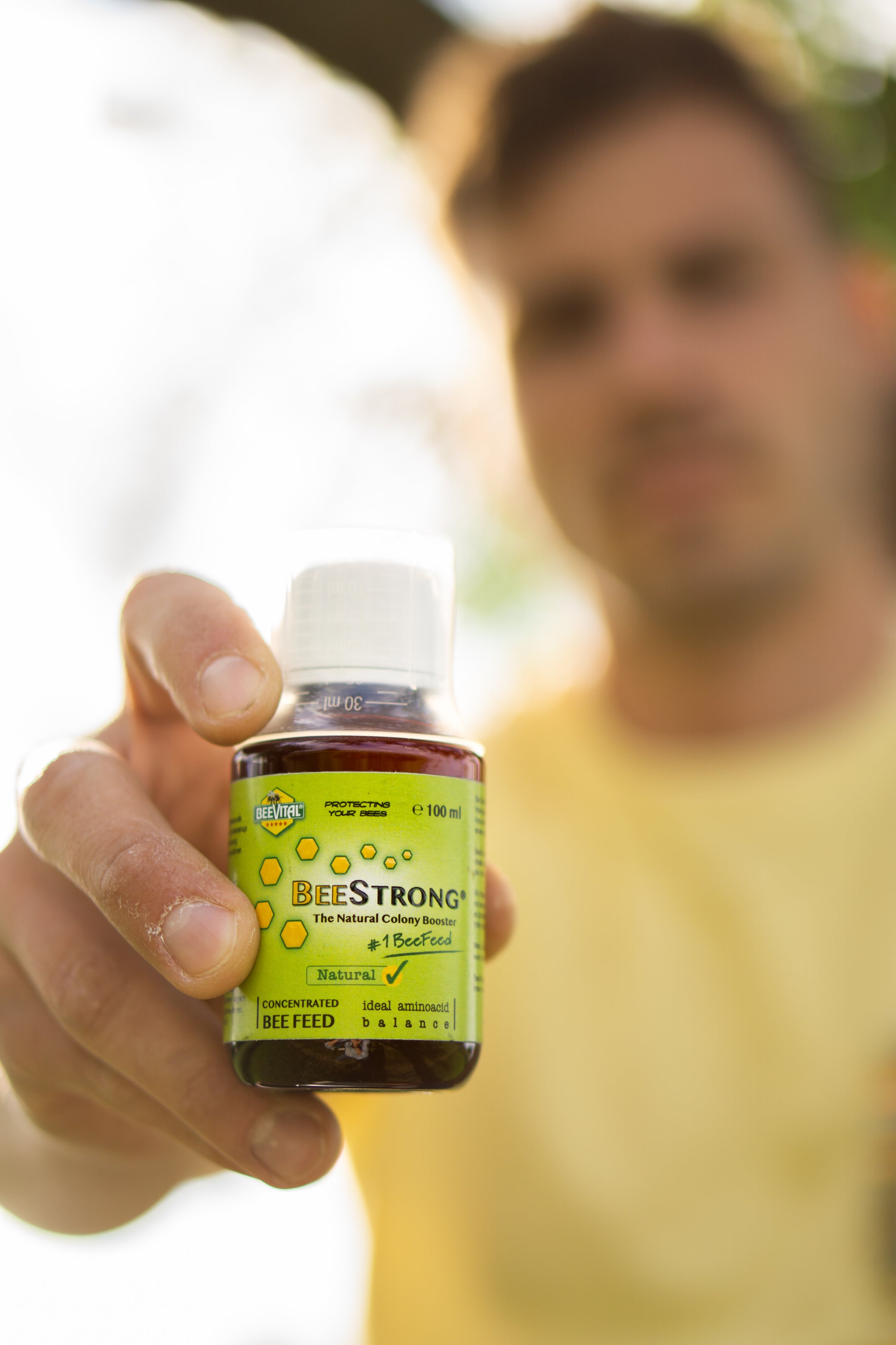 man holding beestrong bottle 100 ml with close up on